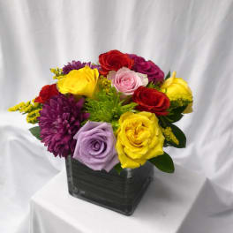 Colorful rose bouquet in a square glass vase