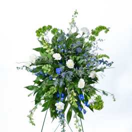 Tall blue and white floral standing spray on an easel