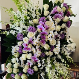Large standing floral spray with white and purple flowers on an easel