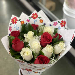 Bouquet of red and white roses wrapped in floral paper