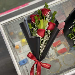 Bouquet of red roses wrapped in black paper with a red ribbon