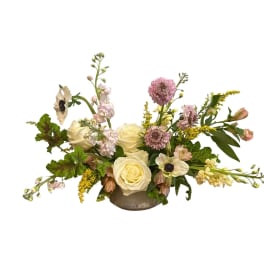 Cream roses and pink flowers arranged in a low vase