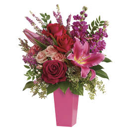Pink and red floral arrangement in a tall pink vase