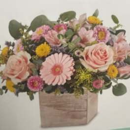 Pink and yellow mixed flower arrangement in a wooden box