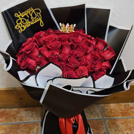 Bouquet of red roses in black and white wrap with a birthday topper