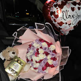 Bouquet of pink, white, red, and lavender roses with heart balloons and a teddy bear