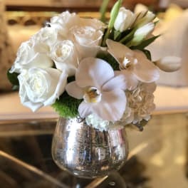 White roses and orchids in a silver vase