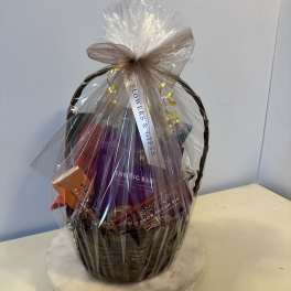 Gift basket wrapped in clear cellophane with a bow