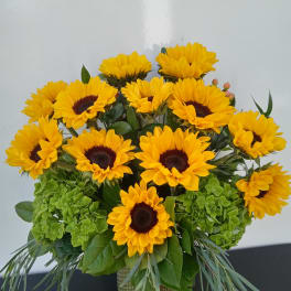 Bouquet of yellow sunflowers in a glass vase