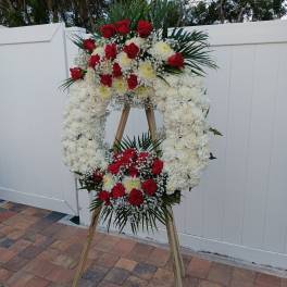 Standing funeral wreath of red roses and white flowers on an easel