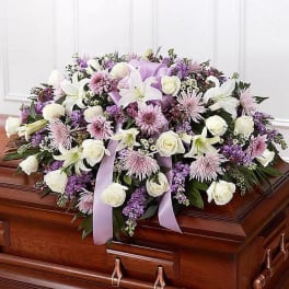 Casket spray with white and lavender flowers and ribbon