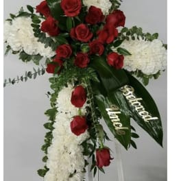 Standing floral spray with red roses and white blooms on a white easel