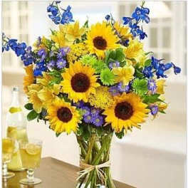 Bouquet of sunflowers and blue flowers in a glass vase