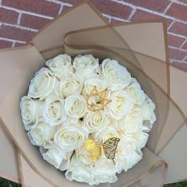 Bouquet of white roses wrapped in tan paper with gold butterfly accents