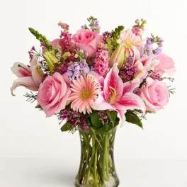 Pink roses and lilies in a clear glass vase