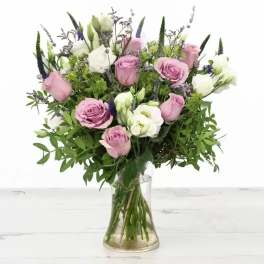 Pink and white roses arranged in a clear glass vase