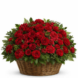 Red roses and carnations arranged in a wicker basket