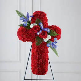 Red floral cross on a stand with blue and white flowers