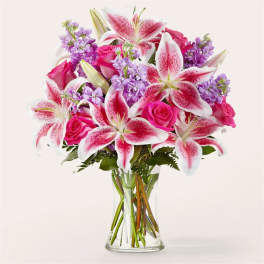Bouquet of pink roses and stargazer lilies in a clear glass vase