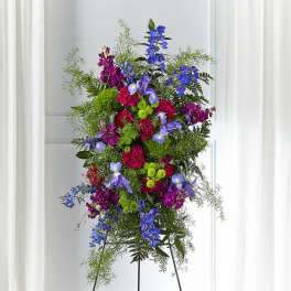 Tall standing floral spray with blue, purple, and pink flowers