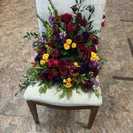 Mixed bouquet of red, yellow, and purple flowers on a chair