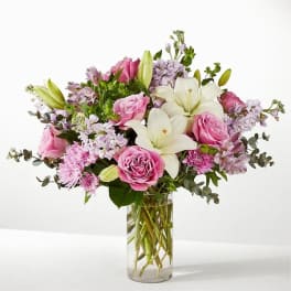 Pink roses and white lilies in a clear glass vase