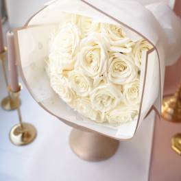 Bouquet of cream roses wrapped in white paper