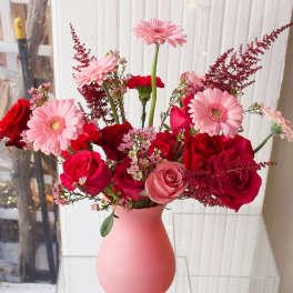 Pink and red mixed bouquet in a matte pink vase