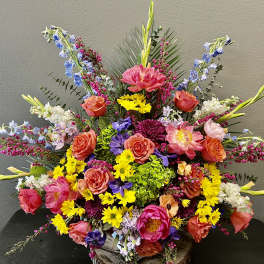 Large colorful floral arrangement with roses, lilies, and mixed blooms