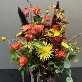 Autumn bouquet of orange and yellow flowers in a glass vase