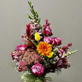 Mixed bouquet with pink roses, orange gerbera, and yellow tulips in a vase