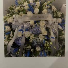 Large white and blue floral spray with a "Loving Mother" ribbon