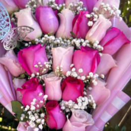 Bouquet of pink and lavender roses with baby's breath in striped wrapping