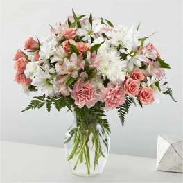 Pink roses and white daisies in a clear glass vase