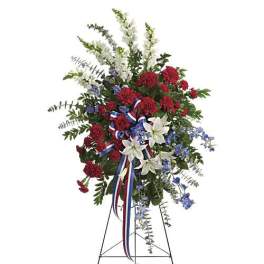 Standing floral spray with red, white, and blue flowers on an easel