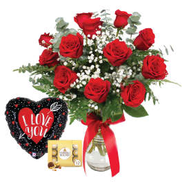 Red roses in a glass vase with a heart balloon and chocolate box