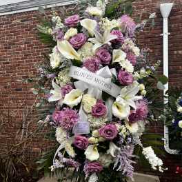 Large standing sympathy spray with pink roses, white lilies, and a ribbon reading Beloved Mother