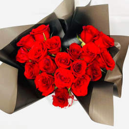 Bouquet of red roses wrapped in black and brown paper
