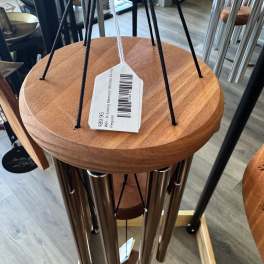 Wooden wind chime with metal tubes and a hanging price tag