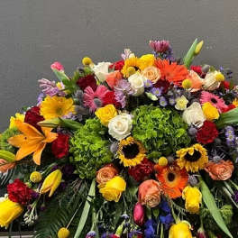 Large colorful floral arrangement with roses, lilies, and gerbera daisies