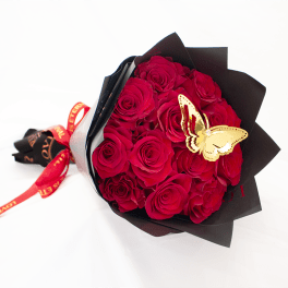 Bouquet of red roses wrapped in black paper with a butterfly decoration