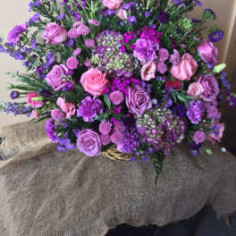 Large bouquet of pink and purple flowers in a basket