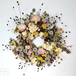 Dried floral wreath with pastel blooms and spiky seed heads