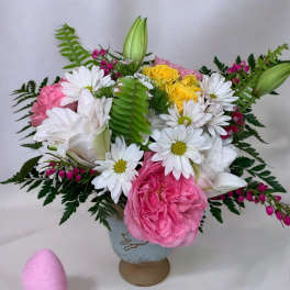 Pink and white flower arrangement with daisies and roses in a vase