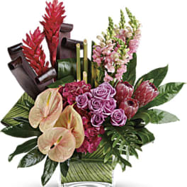 Tropical floral arrangement with pink roses and anthuriums in a glass vase