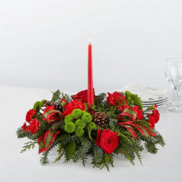 Red floral centerpiece with a tall candle and ribbon accents