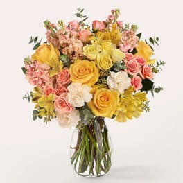 Bouquet of yellow and pink flowers in a clear glass vase