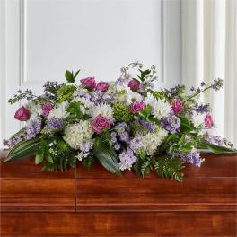 Low floral arrangement with pink roses, white blooms, and purple flowers