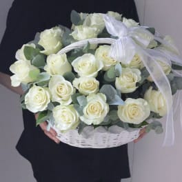 Basket of white roses with eucalyptus and a white ribbon bow