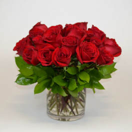 Red roses arranged in a clear glass vase